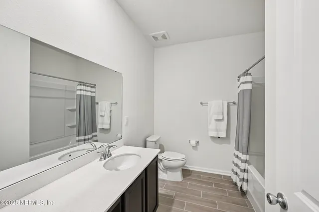 a bathroom with a double vanity sink toilet mirror and shower