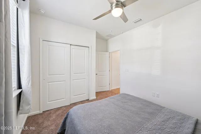 a bedroom with a bed and a chandelier fan