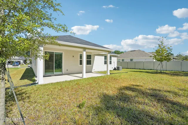 a view of a house with a backyard and a tree