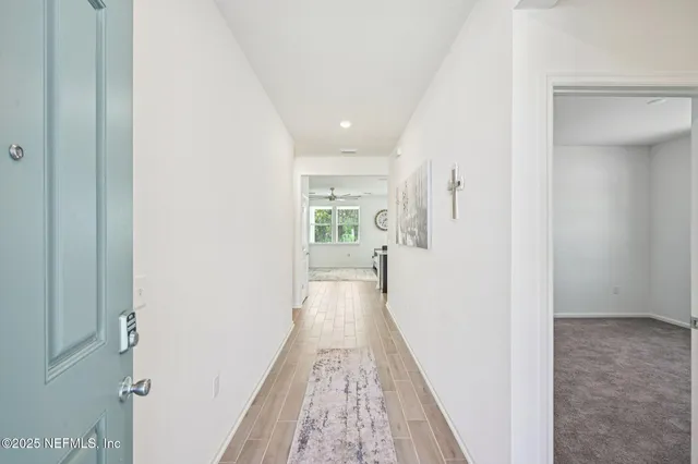a view of a hallway with wooden floor and staircase