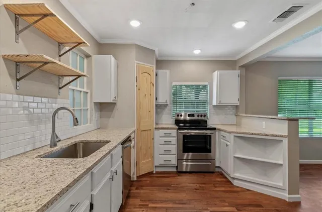 a kitchen with a sink stove top oven and cabinets