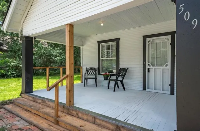 a view of a house with backyard wooden deck and sitting area