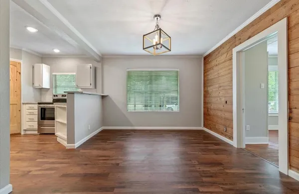 a view of a kitchen with wooden floor and a window