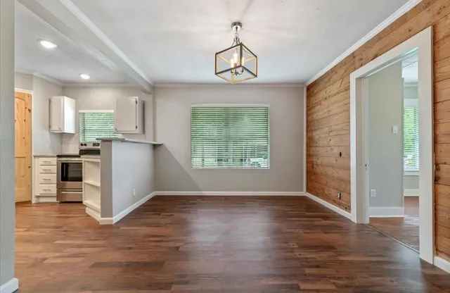 a view of a kitchen with wooden floor and a window