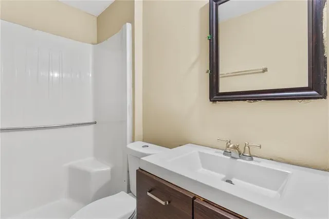 a bathroom with a sink mirror vanity and toilet