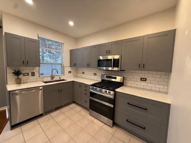 a kitchen with a sink cabinets appliances and a window