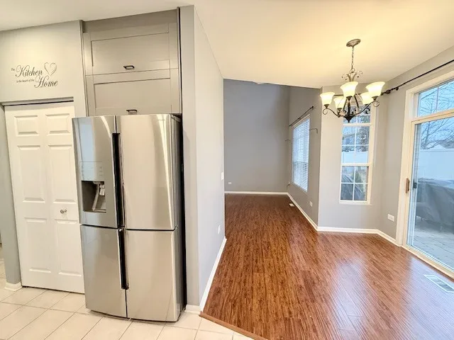 a view of kitchen with refrigerator and wooden floor