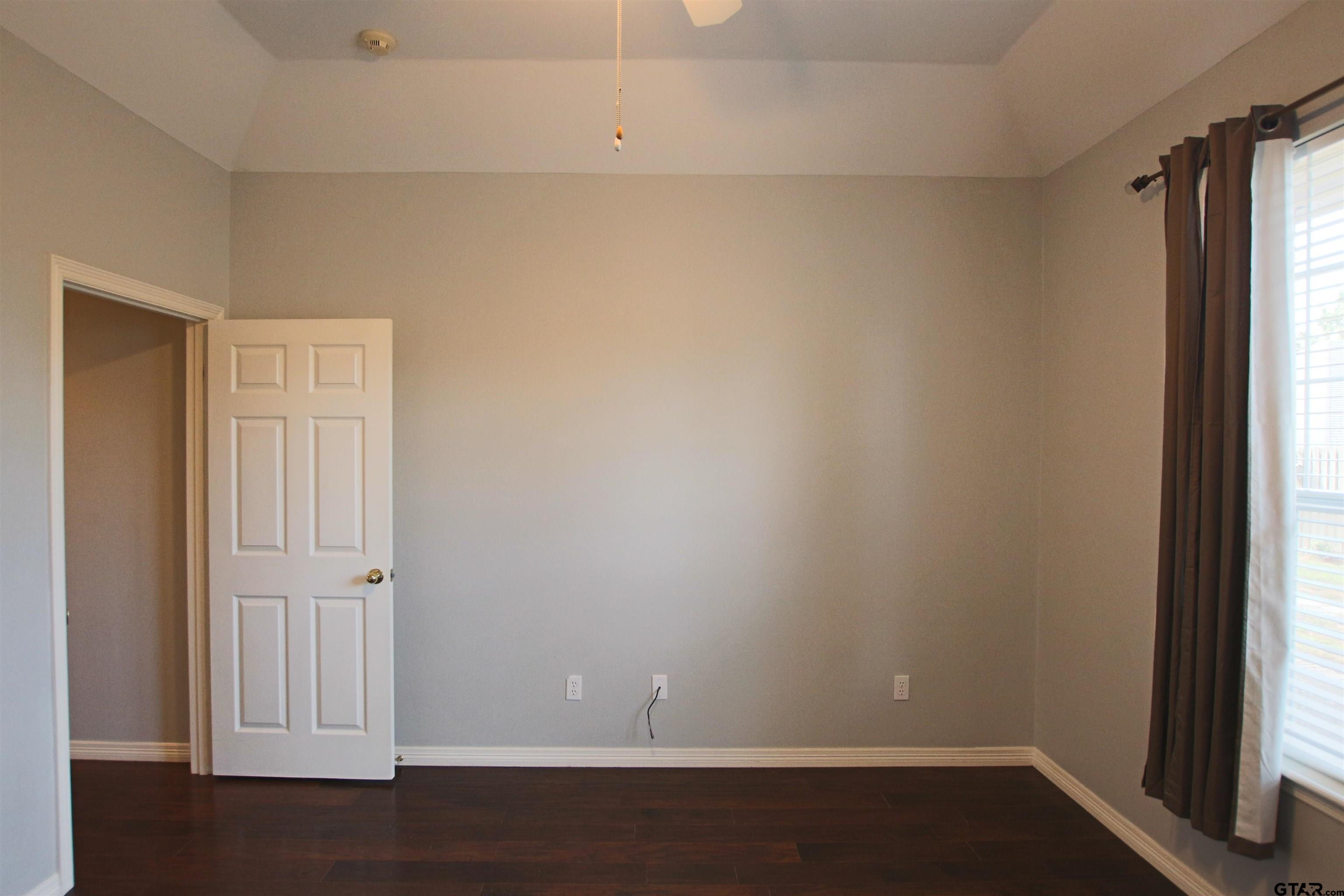 5707 Nicholson Drive Tyler, TX 75707 - Photo 16 of 23 an empty room with wooden floor and windows