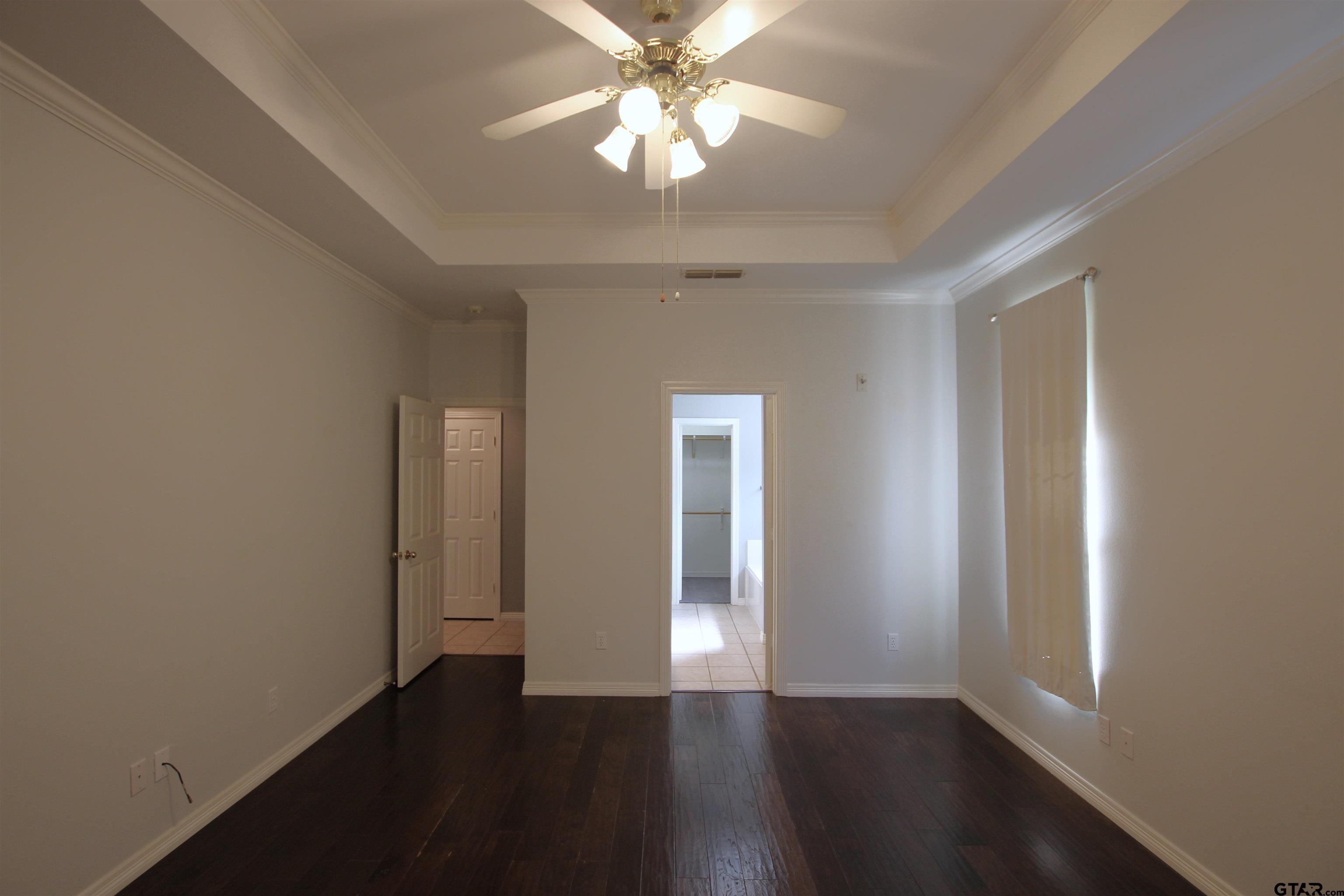 5707 Nicholson Drive Tyler, TX 75707 - Photo 18 of 23 an empty room with wooden floor chandelier fan and windows