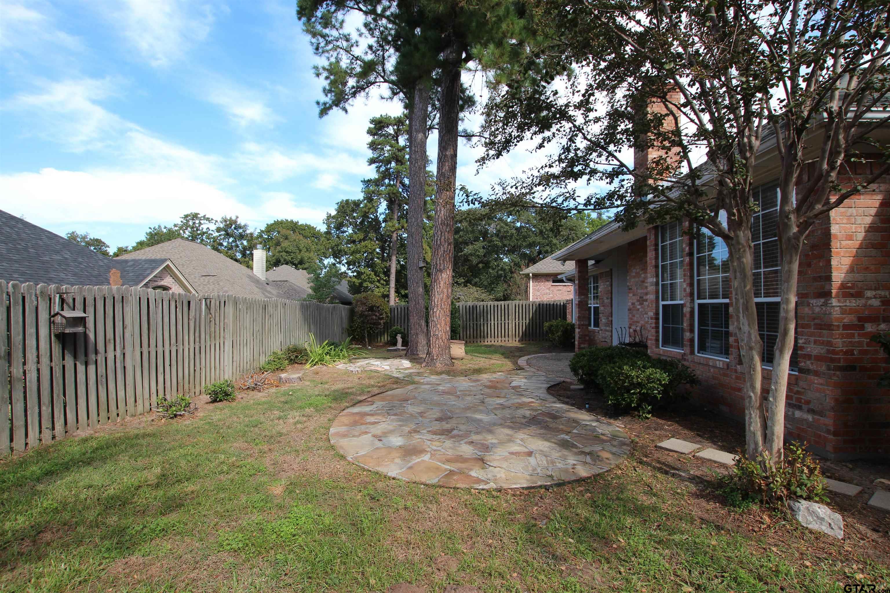5707 Nicholson Drive Tyler, TX 75707 - Photo 23 of 23 a backyard of a house with plants and trees