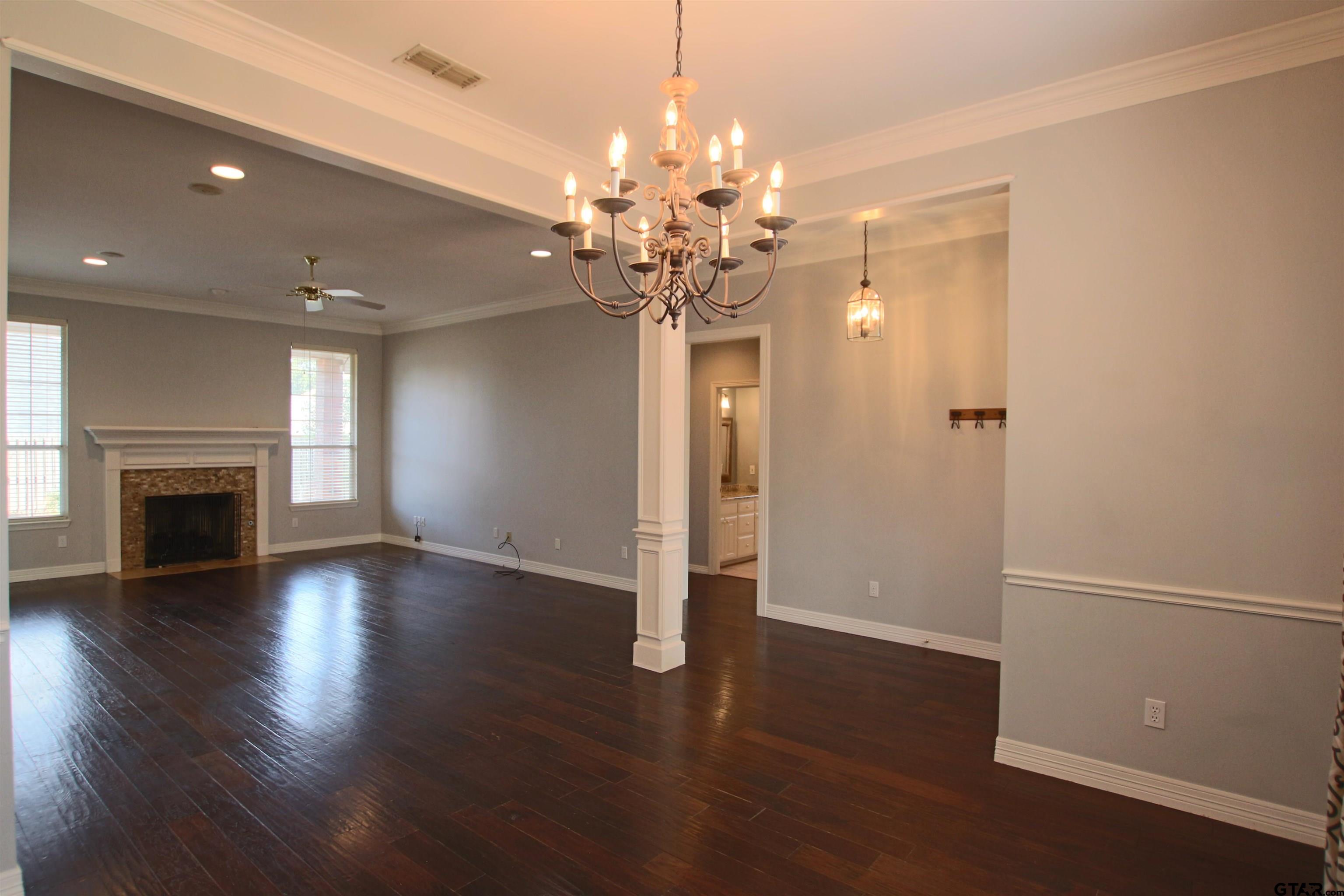 5707 Nicholson Drive Tyler, TX 75707 - Photo 3 of 23 a view of a livingroom with a fireplace wooden floor and chandelier