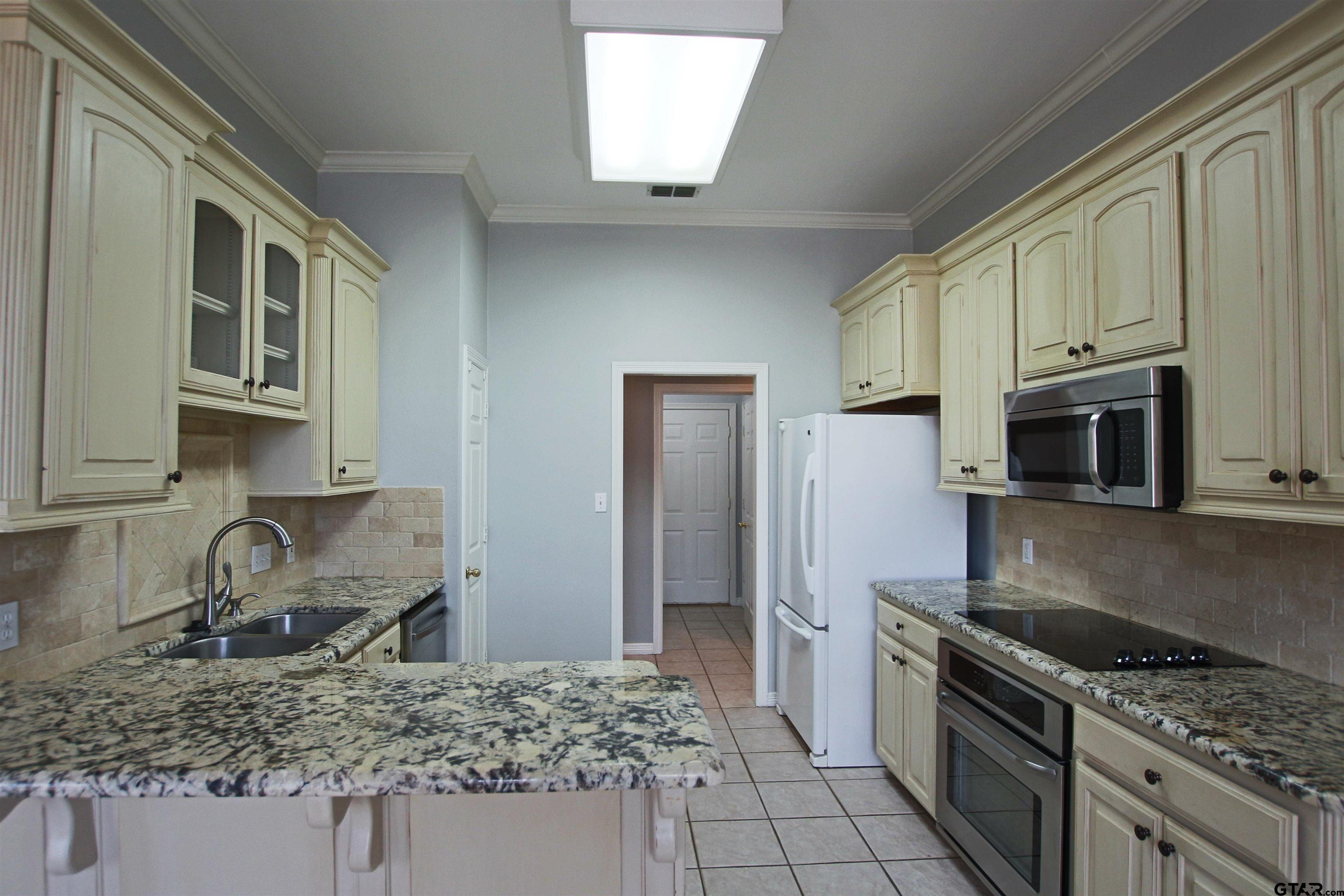 5707 Nicholson Drive Tyler, TX 75707 - Photo 8 of 23 a kitchen with stainless steel appliances granite countertop a sink stove and refrigerator