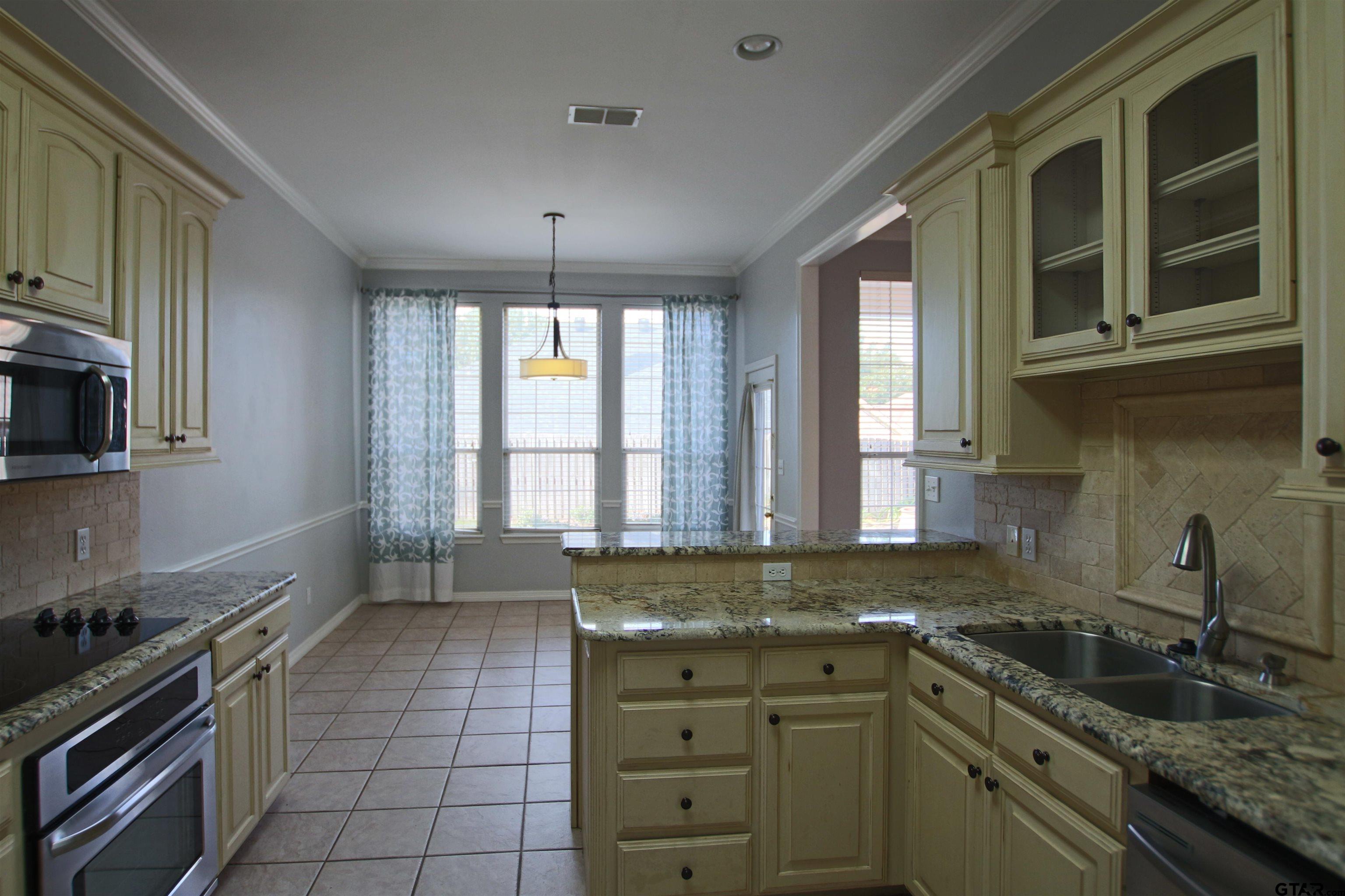 5707 Nicholson Drive Tyler, TX 75707 - Photo 9 of 23 a kitchen with a sink stove and cabinets