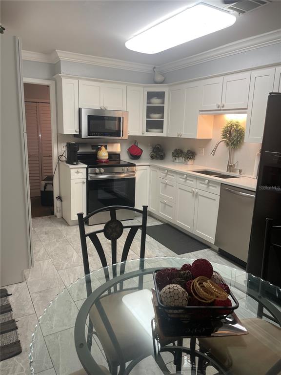 575 Tiberon Cove Road Longwood, FL 32750 - Photo 17 of 56 a kitchen with stainless steel appliances kitchen island granite countertop a sink and cabinets