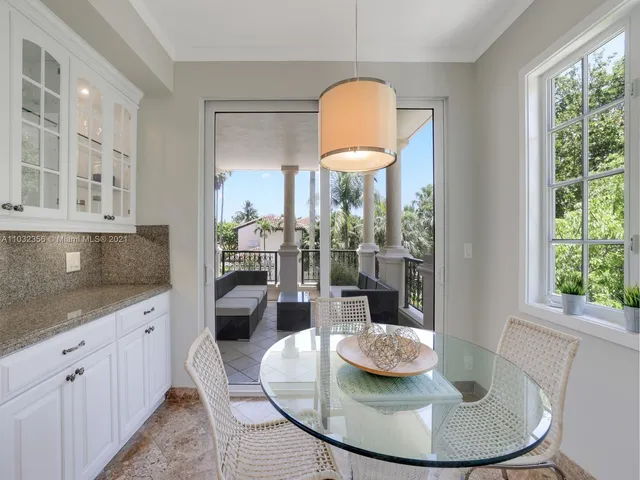 a kitchen with stainless steel appliances granite countertop a stove a refrigerator and a dining table with painted walls