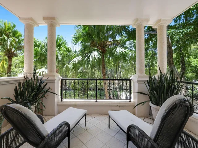 a swimming pool with a lawn chairs under palm trees