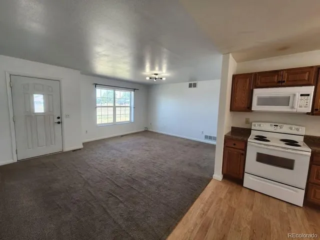 a view of a kitchen with a stove cabinets and a wooden floor