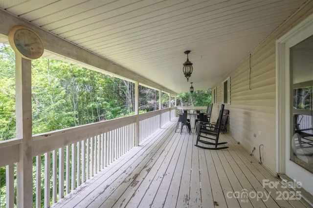 a view of a balcony with chairs and wooden floor