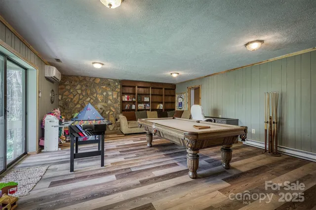 a room with furniture pool table flat screen tv and a large window