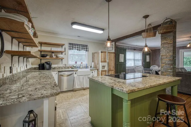 a kitchen with stainless steel appliances granite countertop a sink a stove and a wooden floors