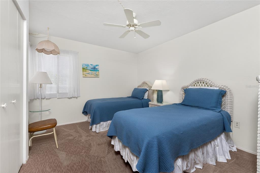 2955 North Beach Road, Unit B614 Englewood, FL 34223 - Photo 30 of 67 a bedroom with two beds and a chandelier