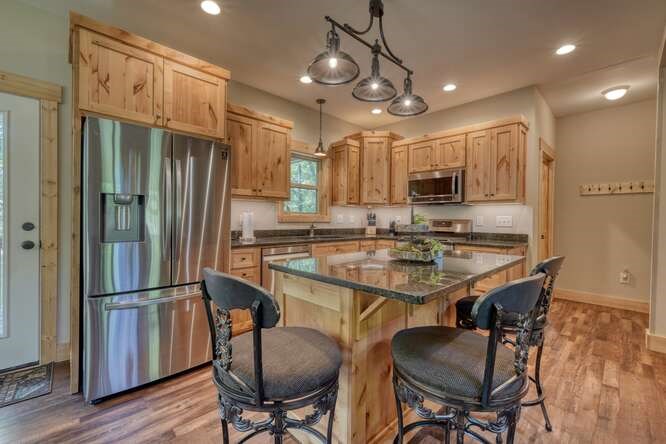 87 Harbin Court Morganton, GA 30560 - Photo 19 of 63 a kitchen with stainless steel appliances granite countertop a refrigerator a stove a sink a dining table and chairs with wooden floor