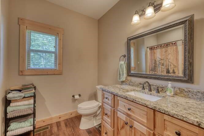 87 Harbin Court Morganton, GA 30560 - Photo 25 of 63 a bathroom with a granite countertop toilet a sink and mirror