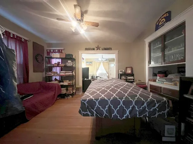 a bed sitting in a bedroom next to a window with bookshelf