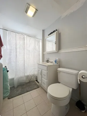 a bathroom with a granite countertop toilet and a sink