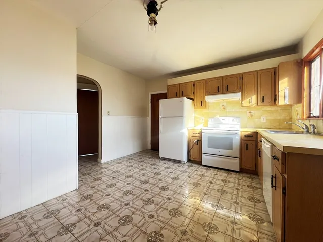 a kitchen with a refrigerator sink and cabinets