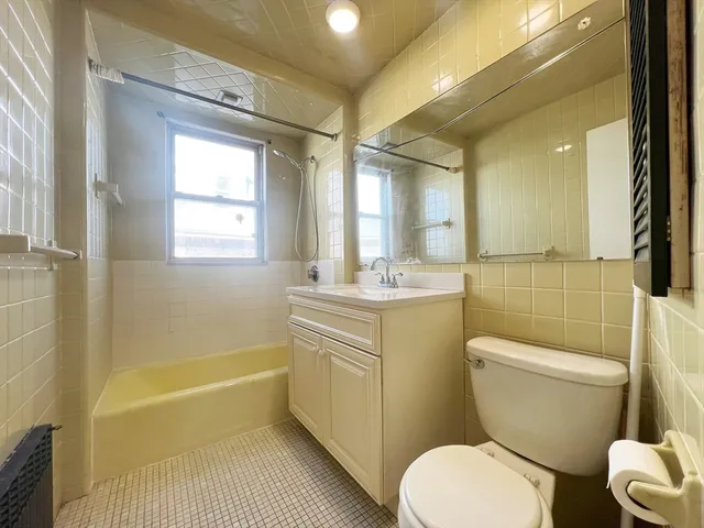 a bathroom with a sink toilet vanity granite tub and shower