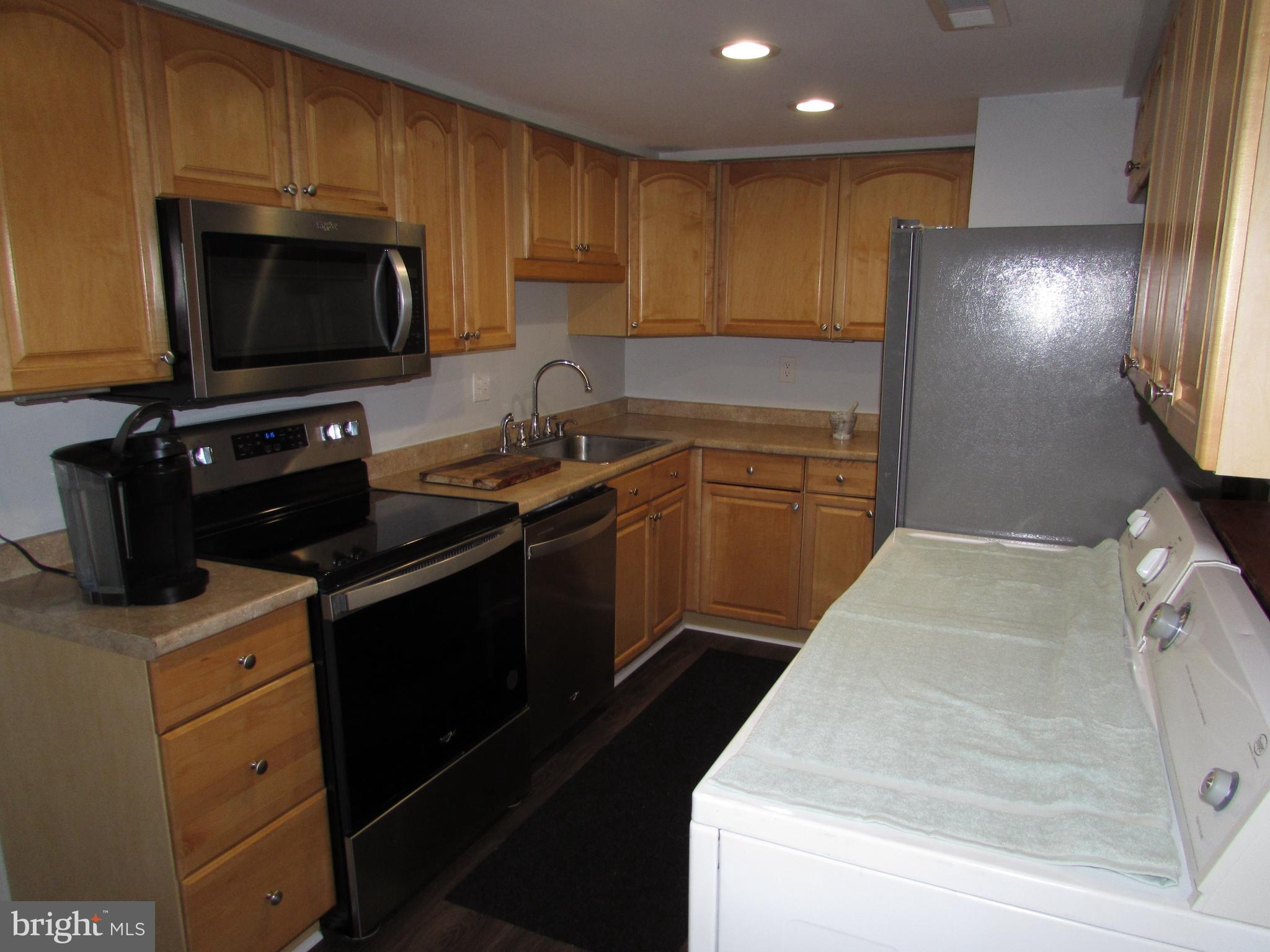 1745 Leisure Way Crofton, MD 21114 - Photo 8 of 14 a kitchen with a sink and a stove top oven with wooden floor