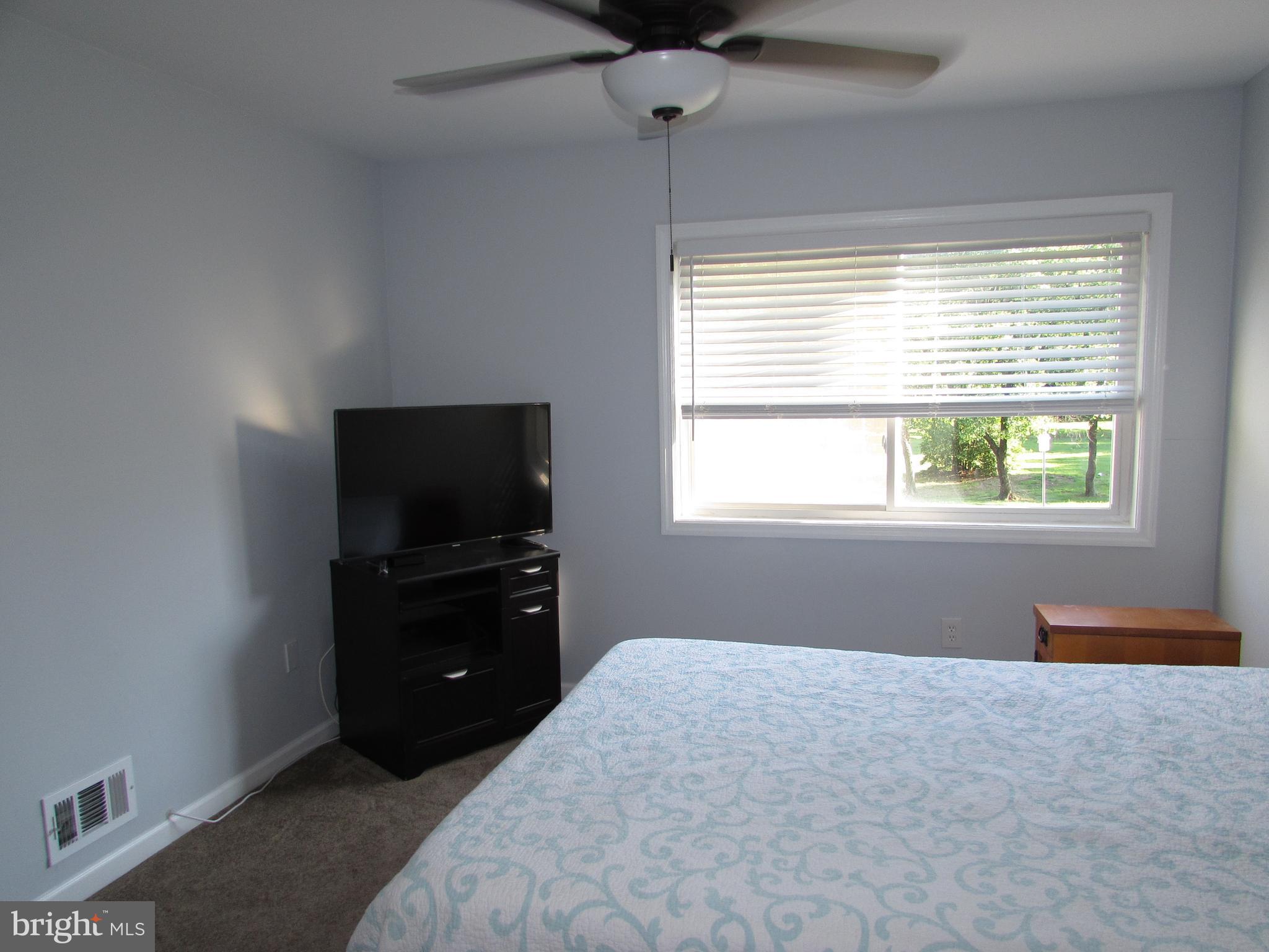 1745 Leisure Way Crofton, MD 21114 - Photo 10 of 14 a bedroom with a bed and a flat tv screen on a dresser