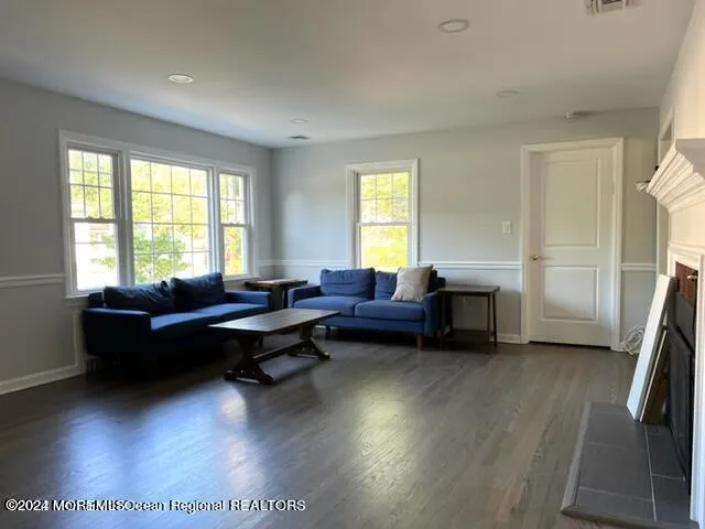 a living room with furniture a large window and a wooden floor