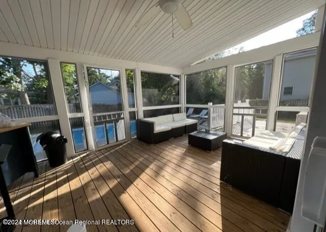 a living room with furniture a flat screen tv and a floor to ceiling window