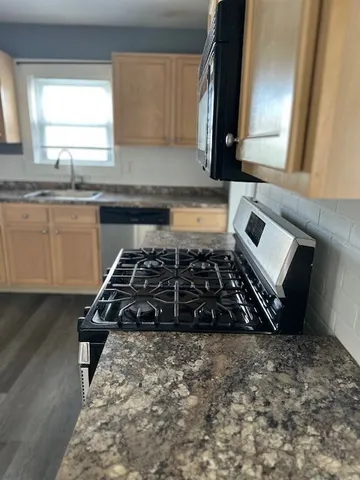 a kitchen with sink a stove and a window