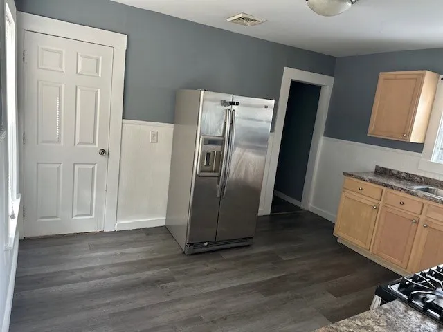 a kitchen with stainless steel appliances granite countertop a refrigerator and a stove