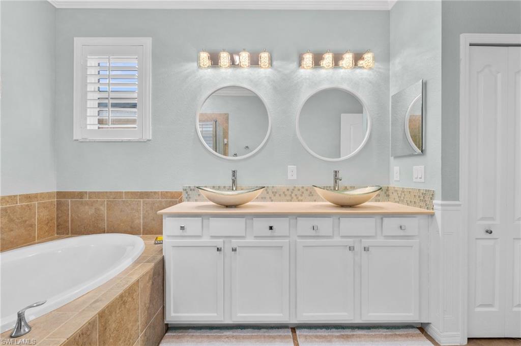 3147 Walnut Grove Lane Alva, FL 33920 - Photo 23 of 45 a bathroom with a granite countertop bathtub sink vanity and mirror