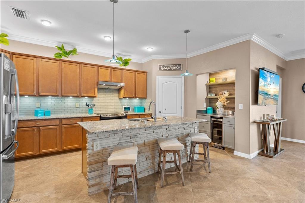 3147 Walnut Grove Lane Alva, FL 33920 - Photo 10 of 45 a kitchen with kitchen island granite countertop wooden cabinets and a refrigerator