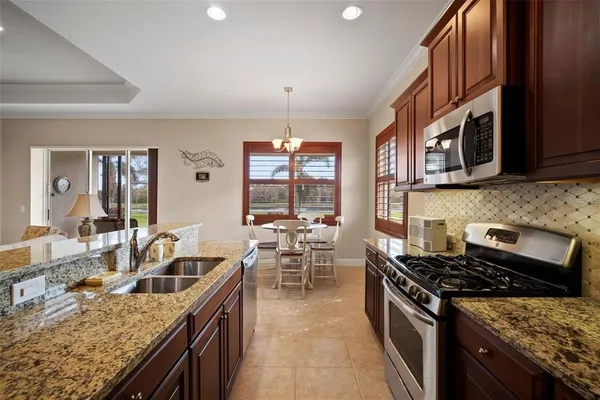 a kitchen with stainless steel appliances granite countertop a stove a sink a refrigerator and a microwave