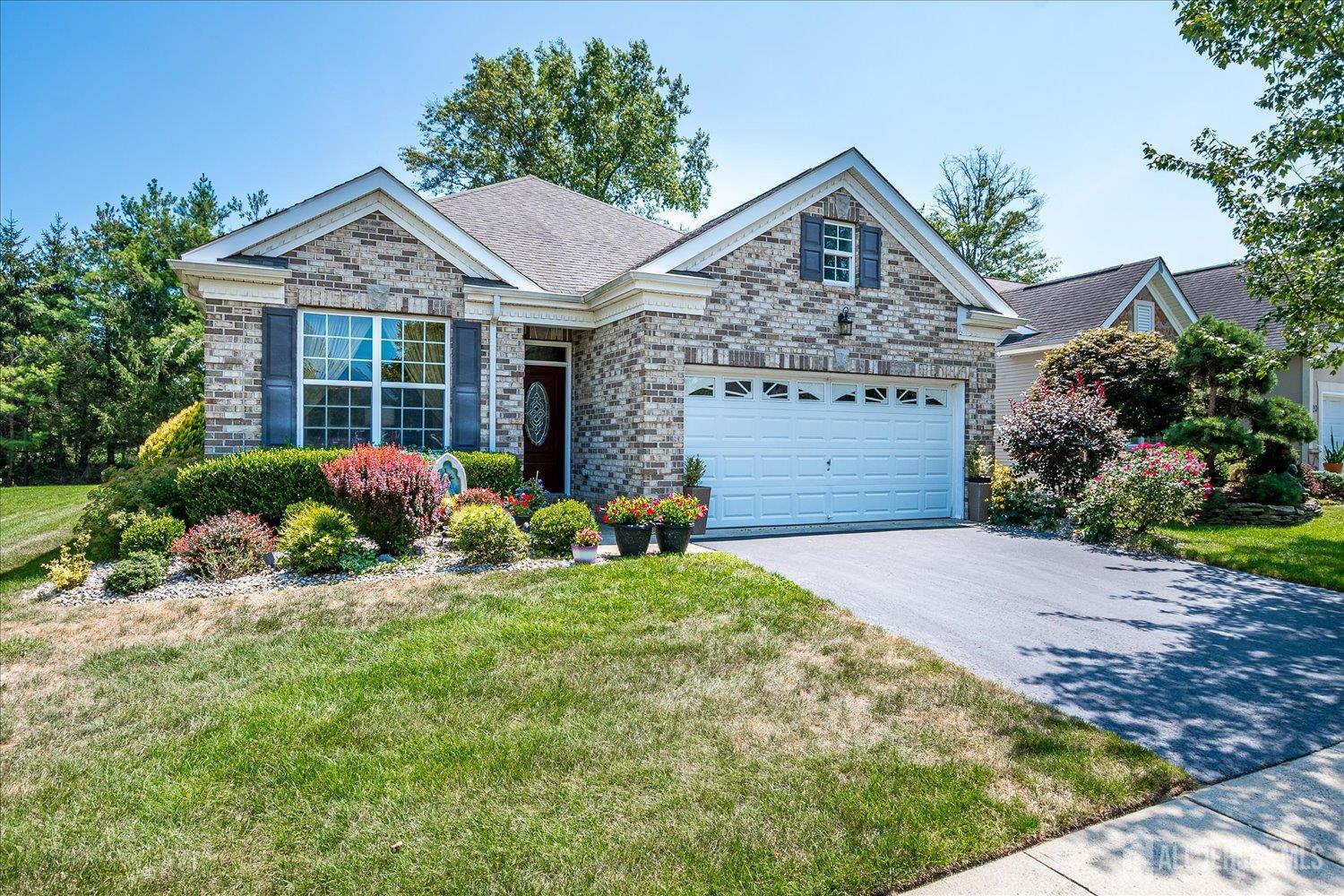 22 Silver Charm Road Manalapan, NJ 07726 - Photo 2 of 51 a front view of a house with a yard and garage