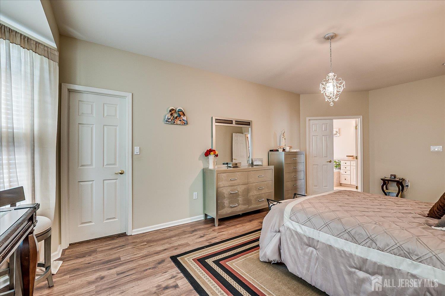 22 Silver Charm Road Manalapan, NJ 07726 - Photo 23 of 51 a bedroom with a bed and wooden floor