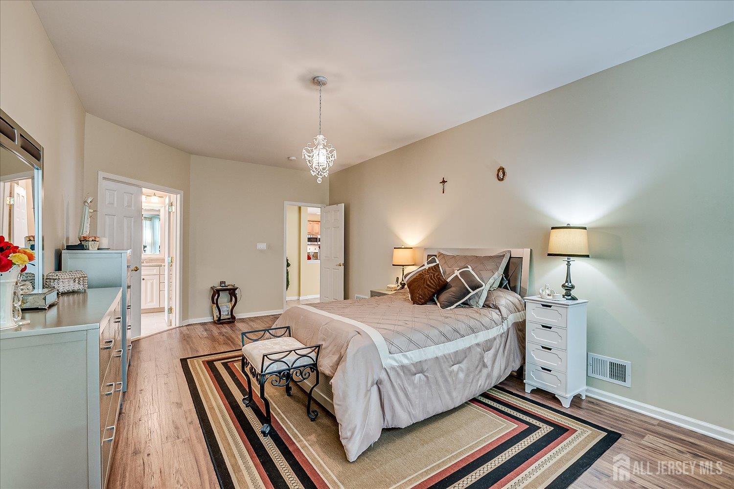 22 Silver Charm Road Manalapan, NJ 07726 - Photo 24 of 51 a bedroom with a bed and a chandelier