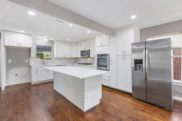 a kitchen with a refrigerator a sink and cabinets