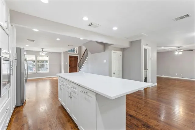 a view of a hallway with wooden floor and staircase