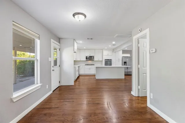 a view of kitchen and hall with wooden floor
