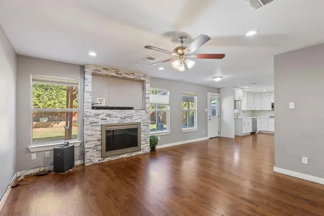 a view of an empty room with a fireplace and a window