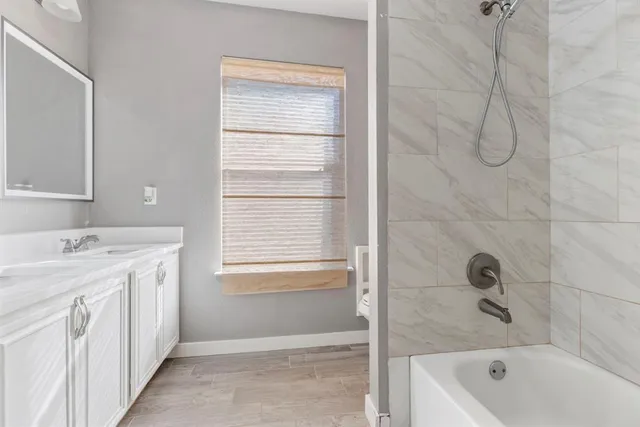 a bathroom with a granite countertop sink a toilet and bathtub