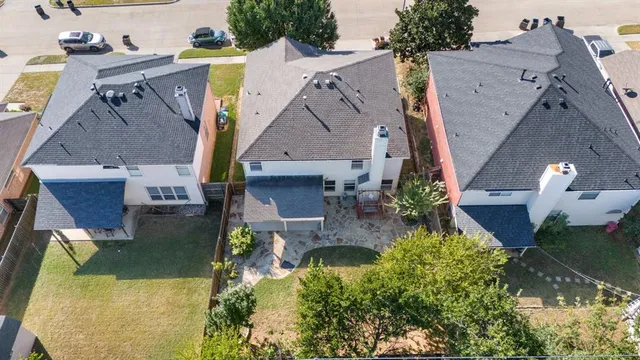 an aerial view of a house with a yard and a large tree