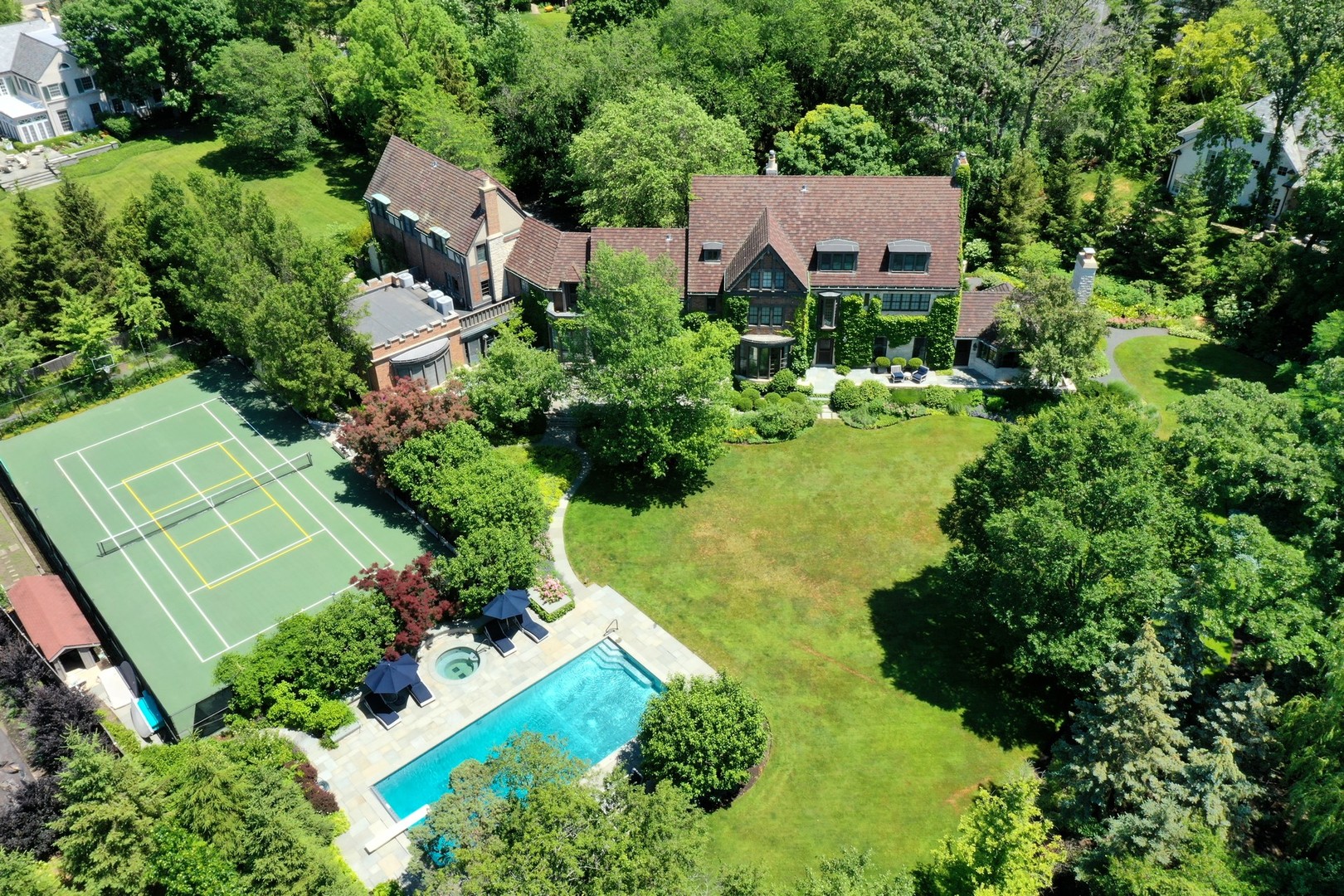 an aerial view of residential house with outdoor space and trees all around